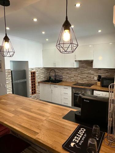 a kitchen with white cabinets and a wooden table at TopHouse Setúbal in Setúbal