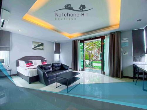 a hotel room with a bed and a couch at Nutchana Hill Boutique Hotel in Ban Thung Ri