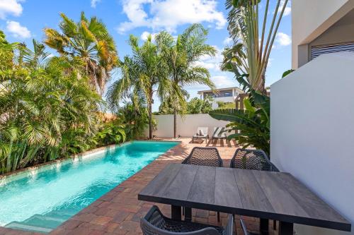 een tafel en stoelen naast een zwembad bij MAJOR. Suites Curaçao in Willemstad