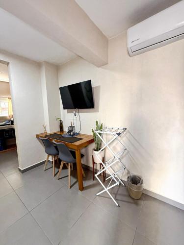 a living room with a table and a television on a wall at Peach35L Céntrico studio super ubicado y tranquilo in Cancún