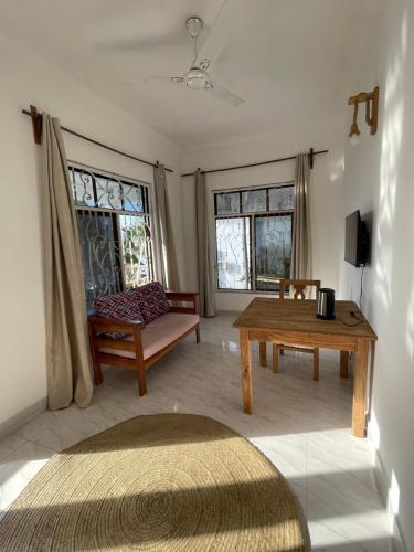 a living room with a table and a couch at Zanzibar beach escape 1&2 in Bwejuu