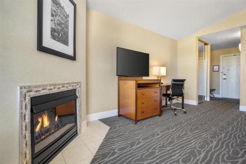 a living room with a fireplace and a television at Best Western Plus Stevenson Manor in Calistoga
