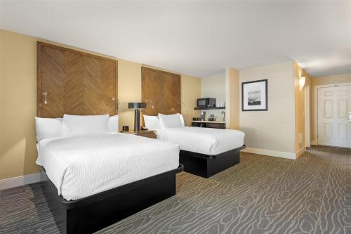 a hotel room with two beds and a desk at Best Western Plus Stevenson Manor in Calistoga