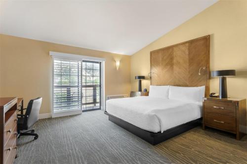 a hotel room with a bed and a desk and a television at Best Western Plus Stevenson Manor in Calistoga