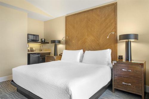 a bedroom with a white bed and a wooden headboard at Best Western Plus Stevenson Manor in Calistoga