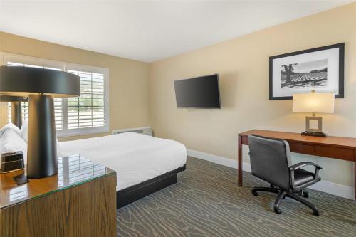 a hotel room with a bed and a desk and a computer at Best Western Plus Stevenson Manor in Calistoga