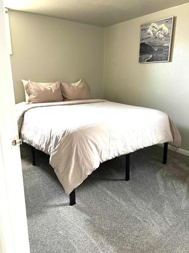a bedroom with a large bed with white sheets and pillows at Cozy basement apartment - blocks from Old Town in Pocatello