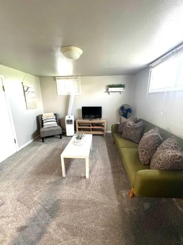 a living room with a green couch and a table at Cozy basement apartment - blocks from Old Town in Pocatello