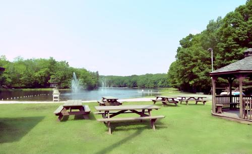 a group of picnic tables and a gazebo near a lake at Poconos Modern Chalet-Hot Tub-Home Theater-Lake in East Stroudsburg