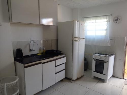 a kitchen with a refrigerator and a sink and a stove at Seu lar in São José