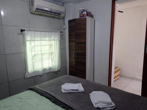 a bedroom with a bed with two towels on it at Seu lar in São José