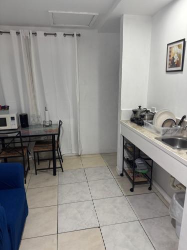 a kitchen with a sink and a table in a room at Pearl of The City BLUE PEARL in Kingston
