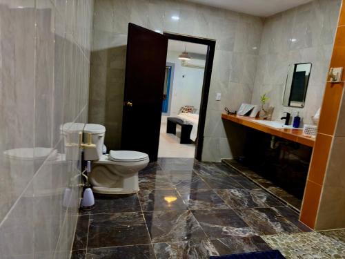 a bathroom with a toilet and a sink and a mirror at Casa La Perla del Sur Confort y calidez en todos sus espacios in Ticul