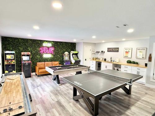 two ping pong tables in a gaming room with machines at Dallas Family Fun Haus with Pool and Massive Game Room in Dallas