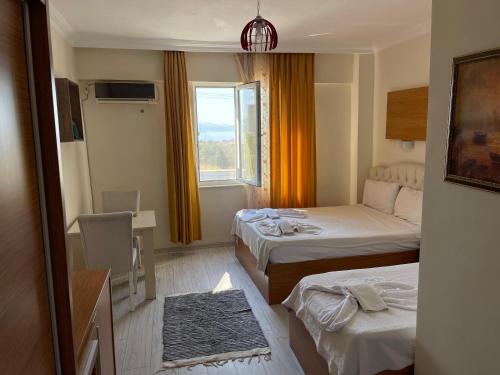 a hotel room with two beds and a window at Grand Alver Otel in Edremit