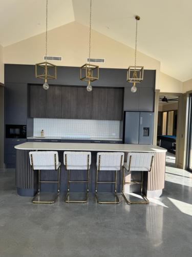 a kitchen with a large kitchen island with bar stools at Happy Stays Braidwood in Braidwood