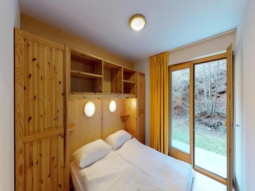 a bedroom with a bed and a large window at Comfy apartment with terrace in Nendaz