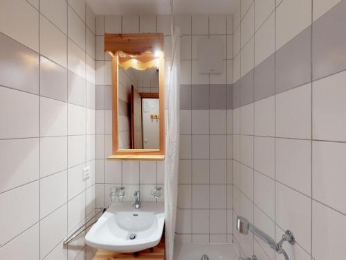 a white bathroom with a sink and a mirror at Comfy apartment with terrace in Nendaz