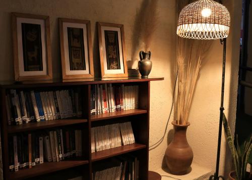 a book shelf filled with books next to a lamp at Portal de La Cumbre in La Cumbre