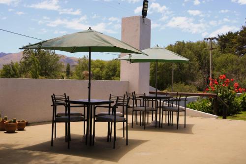 a group of tables and chairs with umbrellas at Portal de La Cumbre in La Cumbre