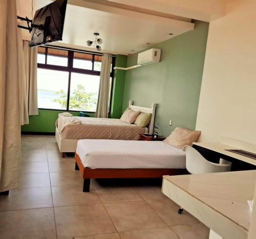 a hotel room with two beds and a window at Las Luciernagas Hotel in Flores