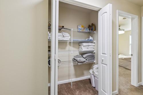 Un vestidor con estantes blancos y toallas. en Central Christiana Moderno, en Newark