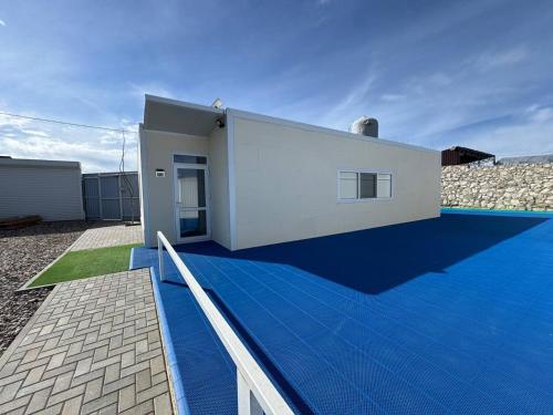 a white house with a blue roof at Your Home 1 