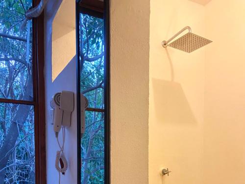 a phone hanging on a wall next to a window at Maracuya Suites Zipolite in Zipolite