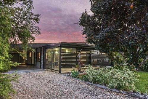 a house with glass doors and a gravel driveway at Gobie Getaway in Kurrimine Beach
