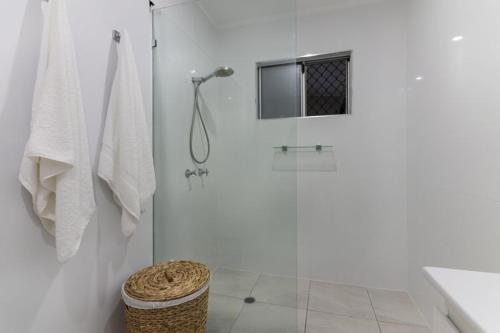 a white bathroom with a shower with a glass door at Gobie Getaway in Kurrimine Beach