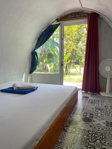 a bedroom with a large bed with a window at The Bear Bungalow in Kampot