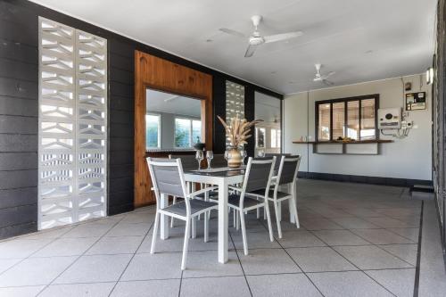 a dining room with a white table and chairs at Gobie Getaway in Kurrimine Beach