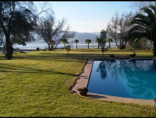 a swimming pool in the middle of a grass field at Casa lago rapel in Lago Rapel