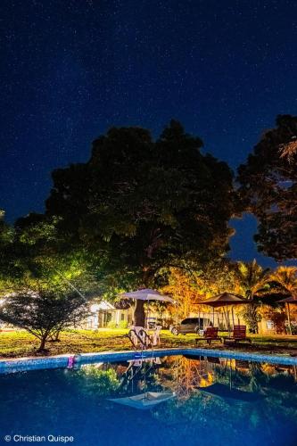 a swimming pool at night next to a house at Chaikoni Lodge in Pucallpa