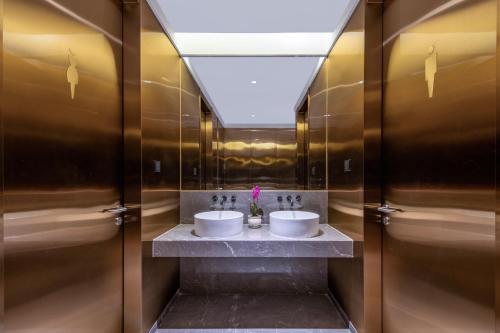 a bathroom with two sinks and a mirror at Orange Beijing Yanqing Badaling Great Wall Hotel in Xibozi