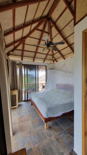 a bedroom with a bed and a ceiling fan at Villa Agualimpia in Puerto Ángel