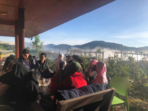 a group of people sitting around a table with a view at Nhà Gỗ Chân Nguyên Villa in Ấp Ða Lôc