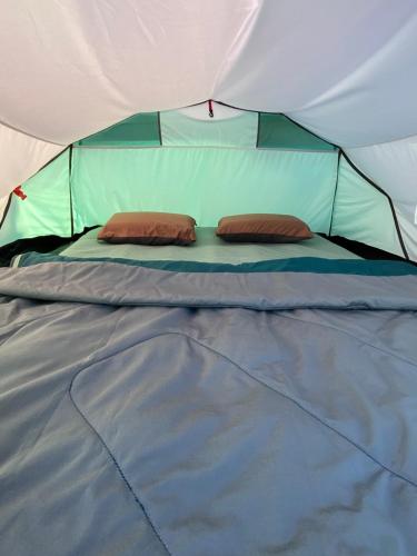 a bed in a tent with two pillows on it at Sea Side Camping in Vama Veche