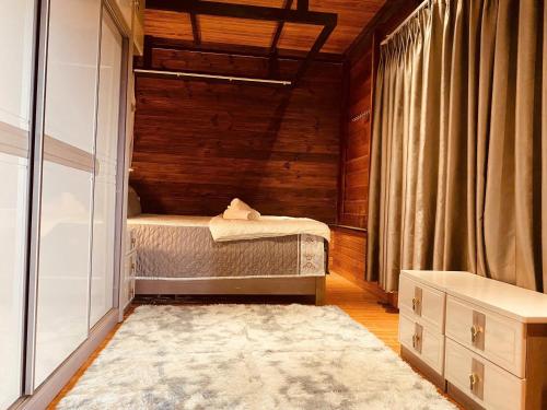 a small bedroom with a bed and a rug at Nhà Gỗ Chân Nguyên Villa in Ấp Ða Lôc