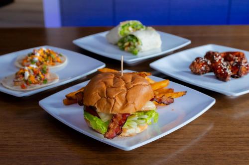 a table with four white plates with a sandwich and french fries at The Cove Hotel in Long Beach