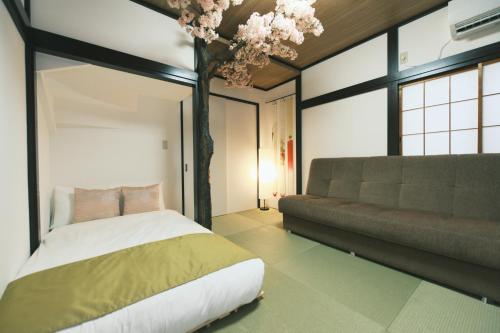a bedroom with a bed and a couch at Ukiyoan Kachofugetsu in Tokyo