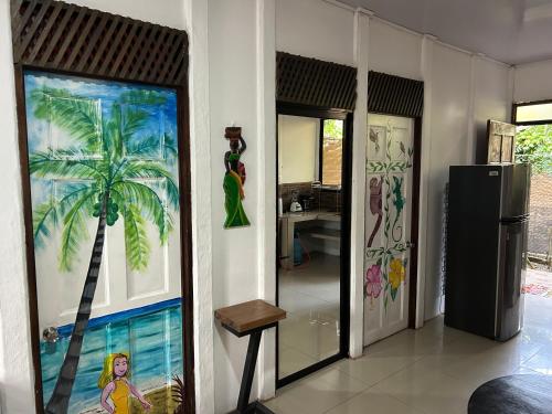 a room with a painting of a palm tree on the wall at Casa Teo número 2 in Puerto Viejo