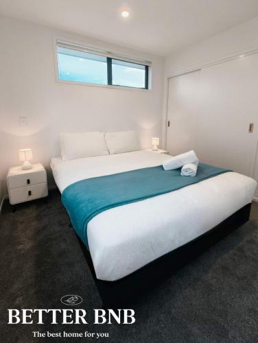 a bedroom with a large bed with a window at Modern and New 3 Beds fancy home in Upper Hutt