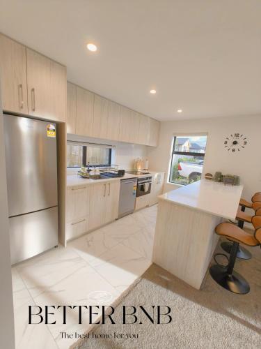 a kitchen with a refrigerator and a table in it at Modern and New 3 Beds fancy home in Upper Hutt