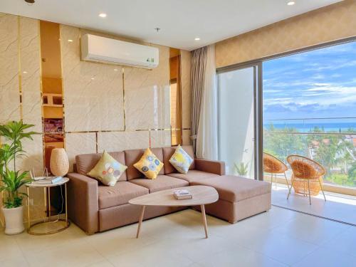 a living room with a couch and a large window at The Song Boutique Apartment in Vung Tau