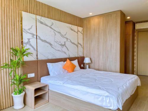 a bedroom with a bed with a painting on the wall at The Song Boutique Apartment in Vung Tau