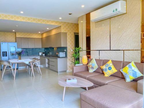 a living room with a couch and a kitchen at The Song Boutique Apartment in Vung Tau