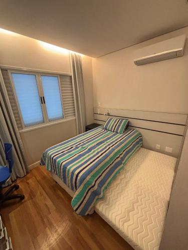 a small bedroom with a bed and a window at Suíte Home Office no Cruzeiro in Brasília