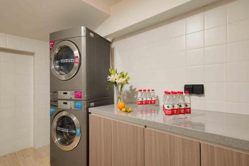 a kitchen with a washer and dryer next to a counter at Orange Beijing Yanqing Badaling Great Wall Hotel in Xibozi