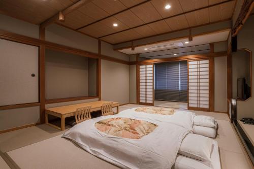 a room with a bed and a table in it at Shinzan Kinosaki in Toyooka